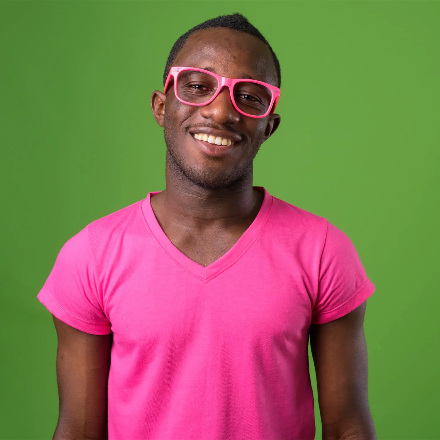 Black man in pink glasses and a pink t-shirt on a green wall