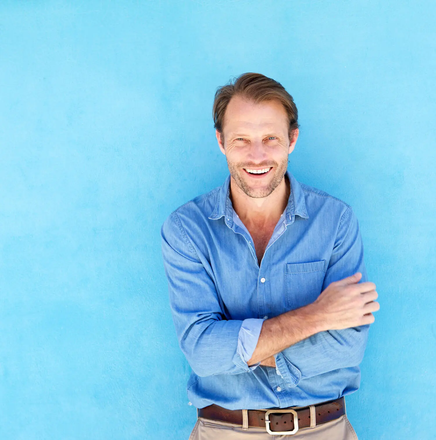 Man in a blue shirt standing in front of a blue wall